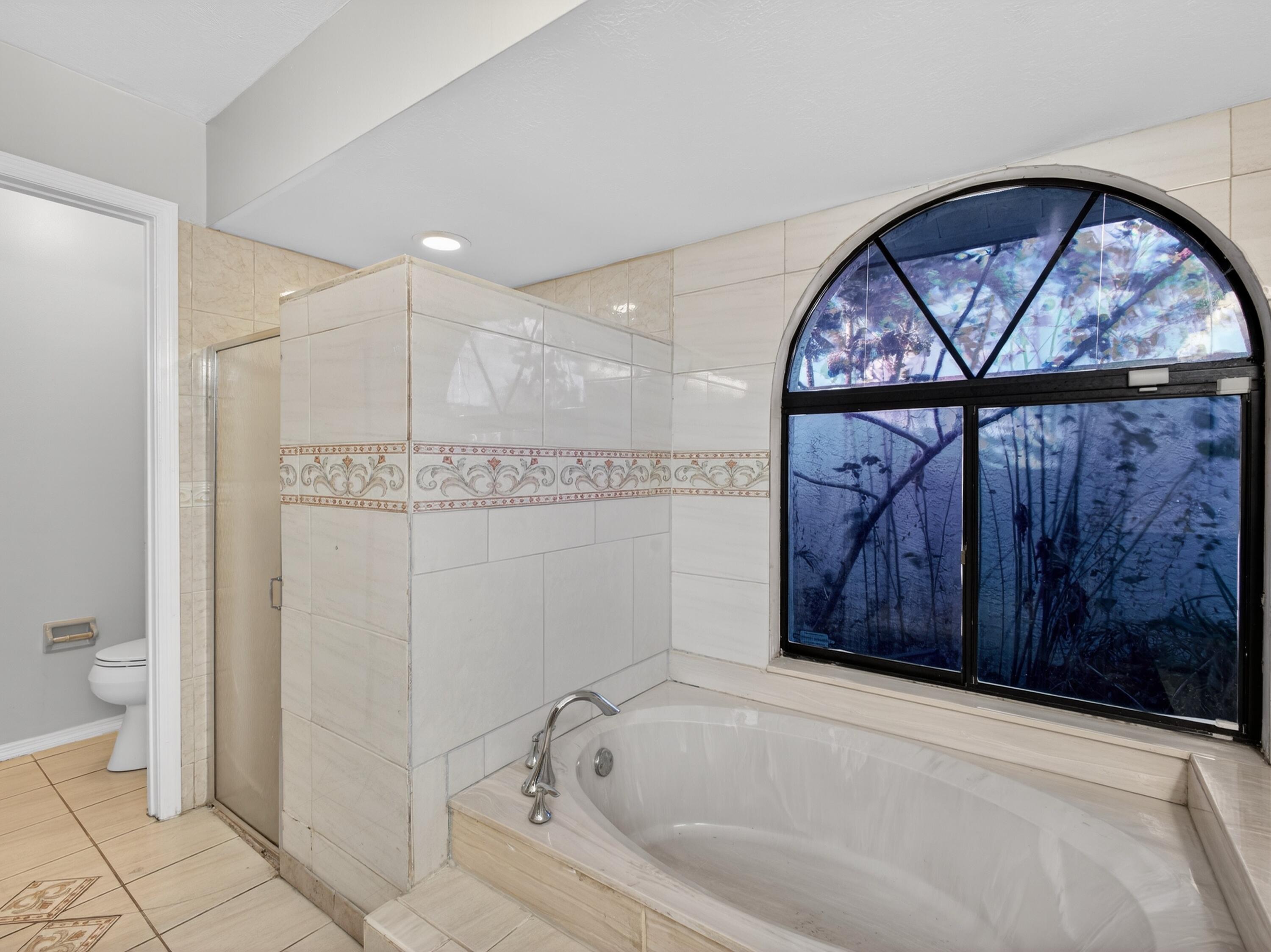 566 Southeast Damask Avenue Port St. Lucie, FL 34983 - Photo 17 of 30 a bathroom with a bathtub and a shower