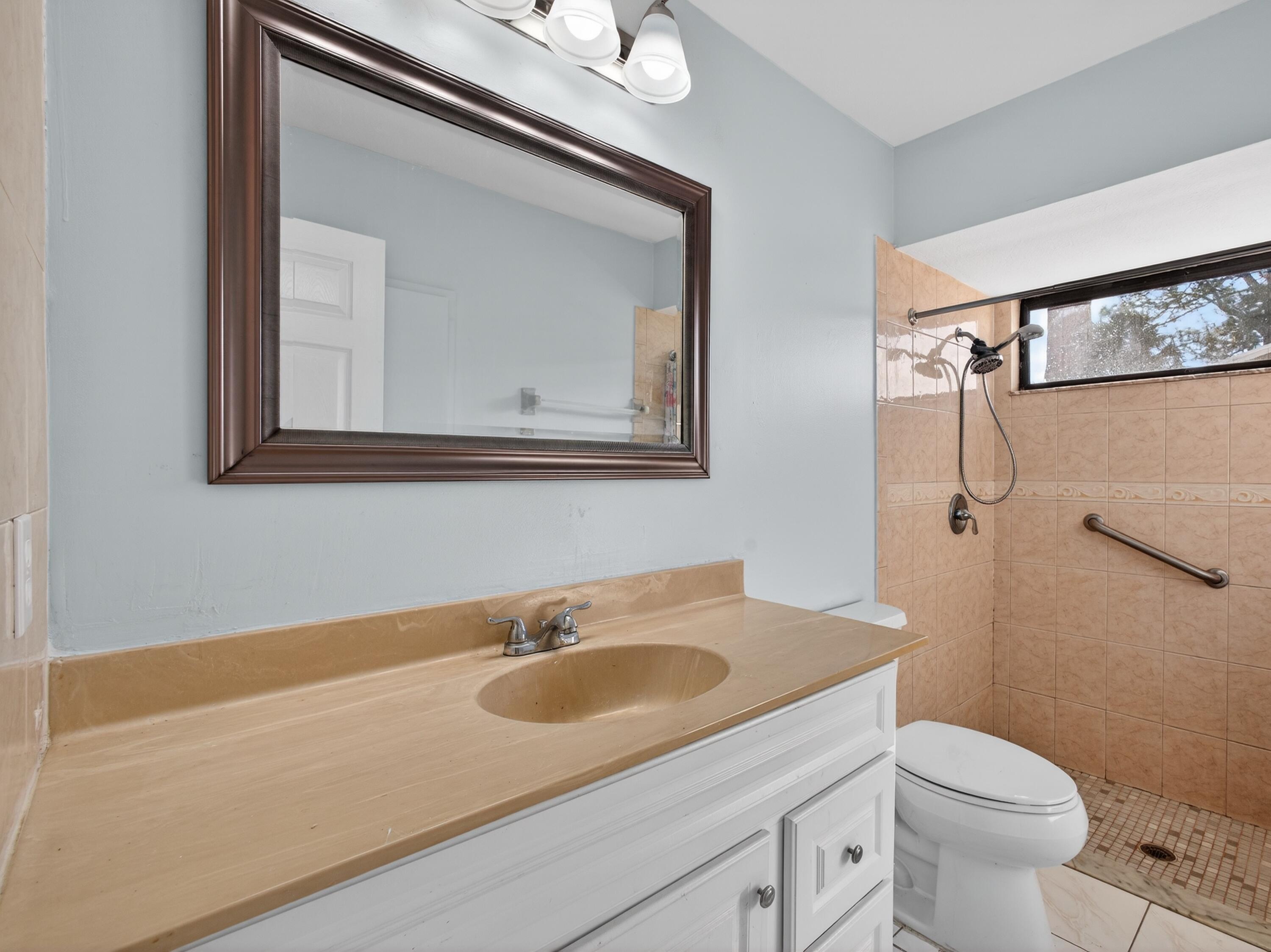 566 Southeast Damask Avenue Port St. Lucie, FL 34983 - Photo 18 of 30 a bathroom with a sink toilet and mirror