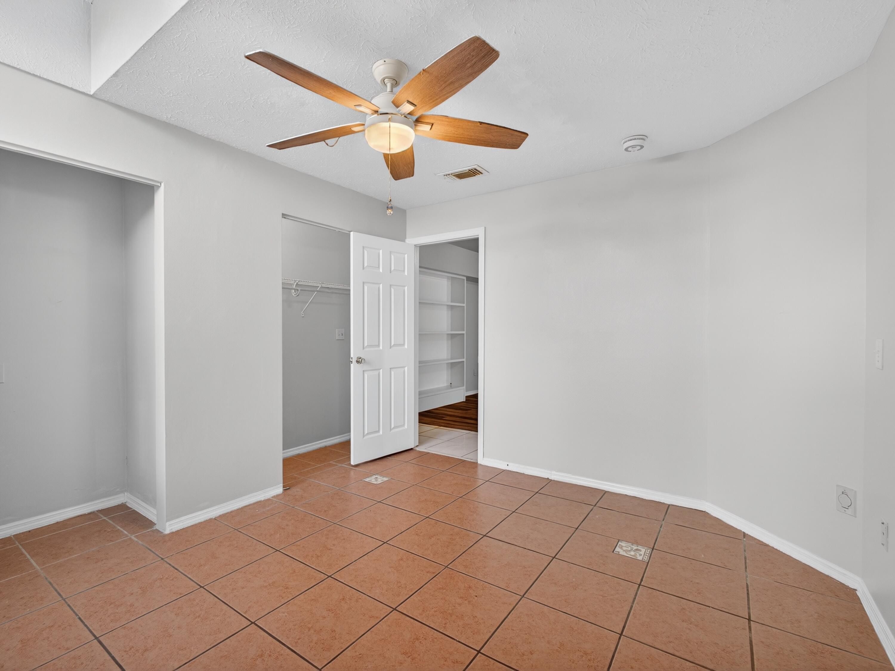 566 Southeast Damask Avenue Port St. Lucie, FL 34983 - Photo 19 of 30 an empty room with closet and fan