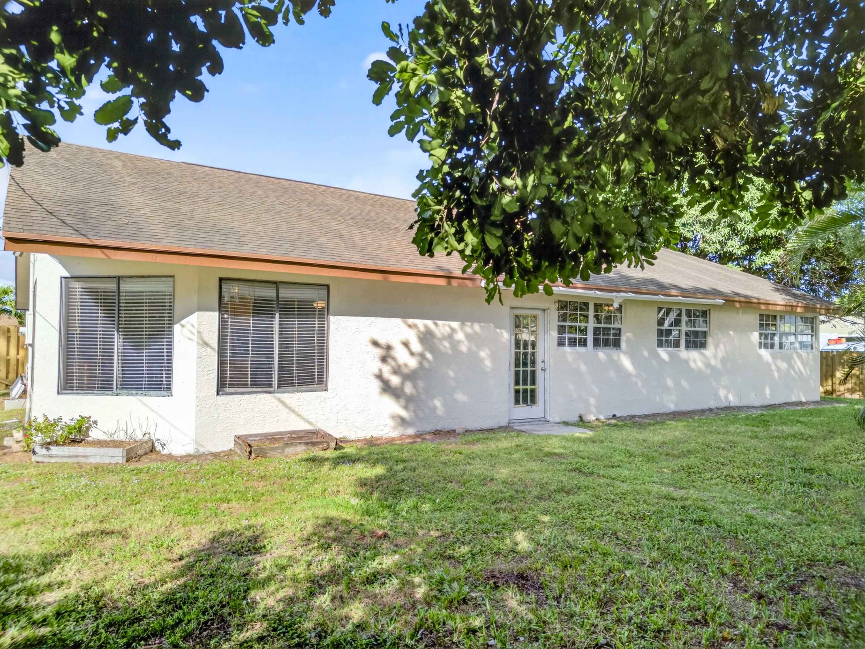 566 Southeast Damask Avenue Port St. Lucie, FL 34983 - Photo 28 of 30 front view of a house with a yard