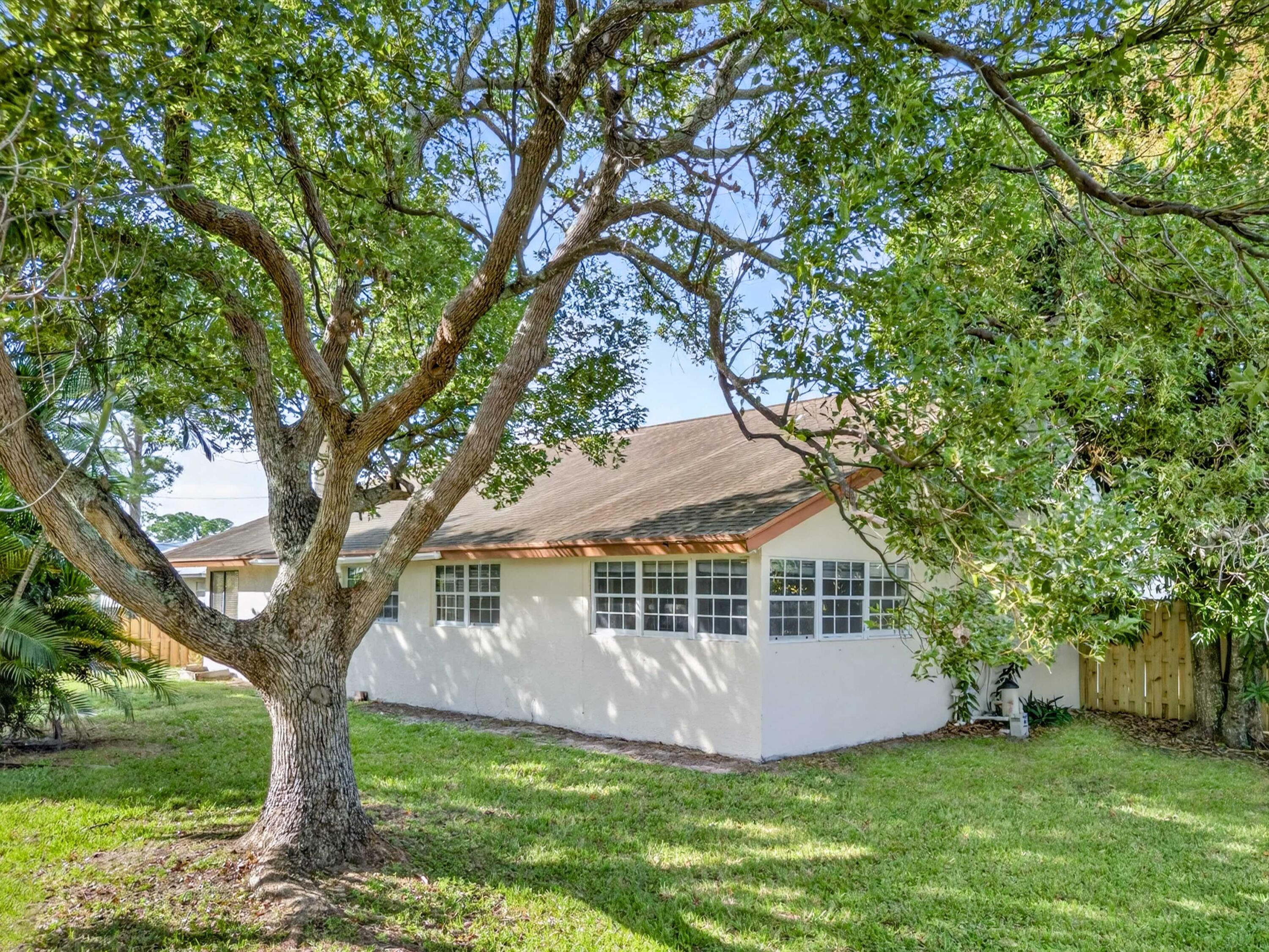 566 Southeast Damask Avenue Port St. Lucie, FL 34983 - Photo 29 of 30 a view of a house with a yard deck and a large tree