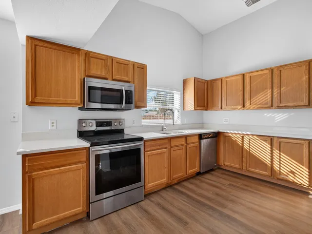 a large kitchen with stainless steel appliances granite countertop a stove a sink and a refrigerator