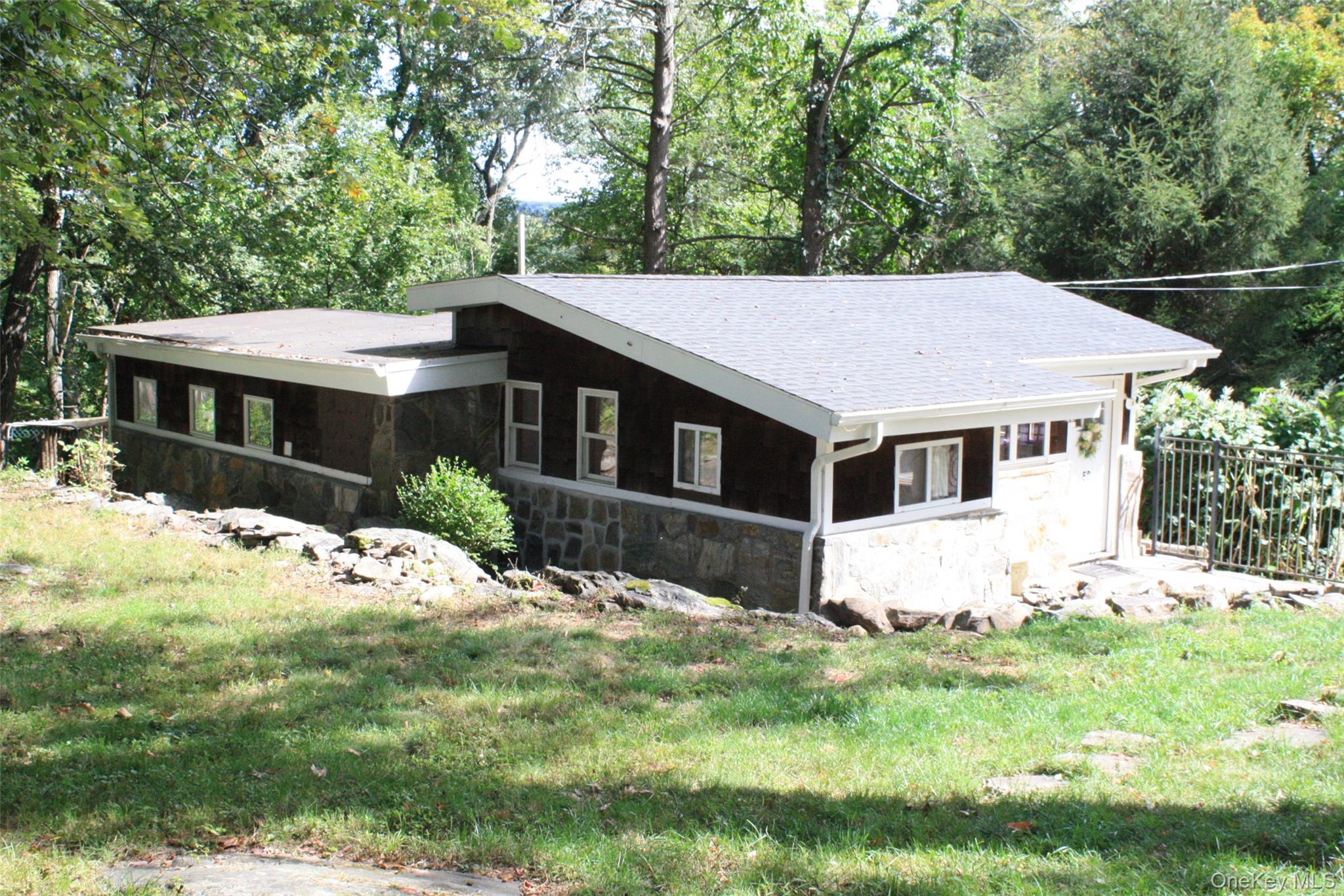 50 Mt Hope Road Carmel, NY 10512 - Photo 2 of 13 View of side of property featuring stone siding, a yard, a shingled roof, and view of scattered trees