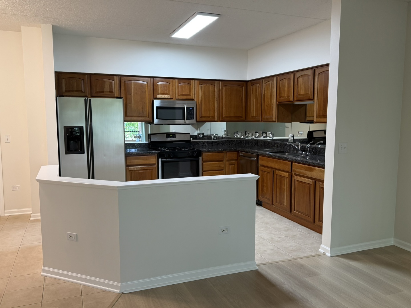 3401 North Carriageway Drive, Unit 307 Arlington Heights, IL 60004 - Photo 3 of 11 a living room with stainless steel appliances furniture and wooden floor