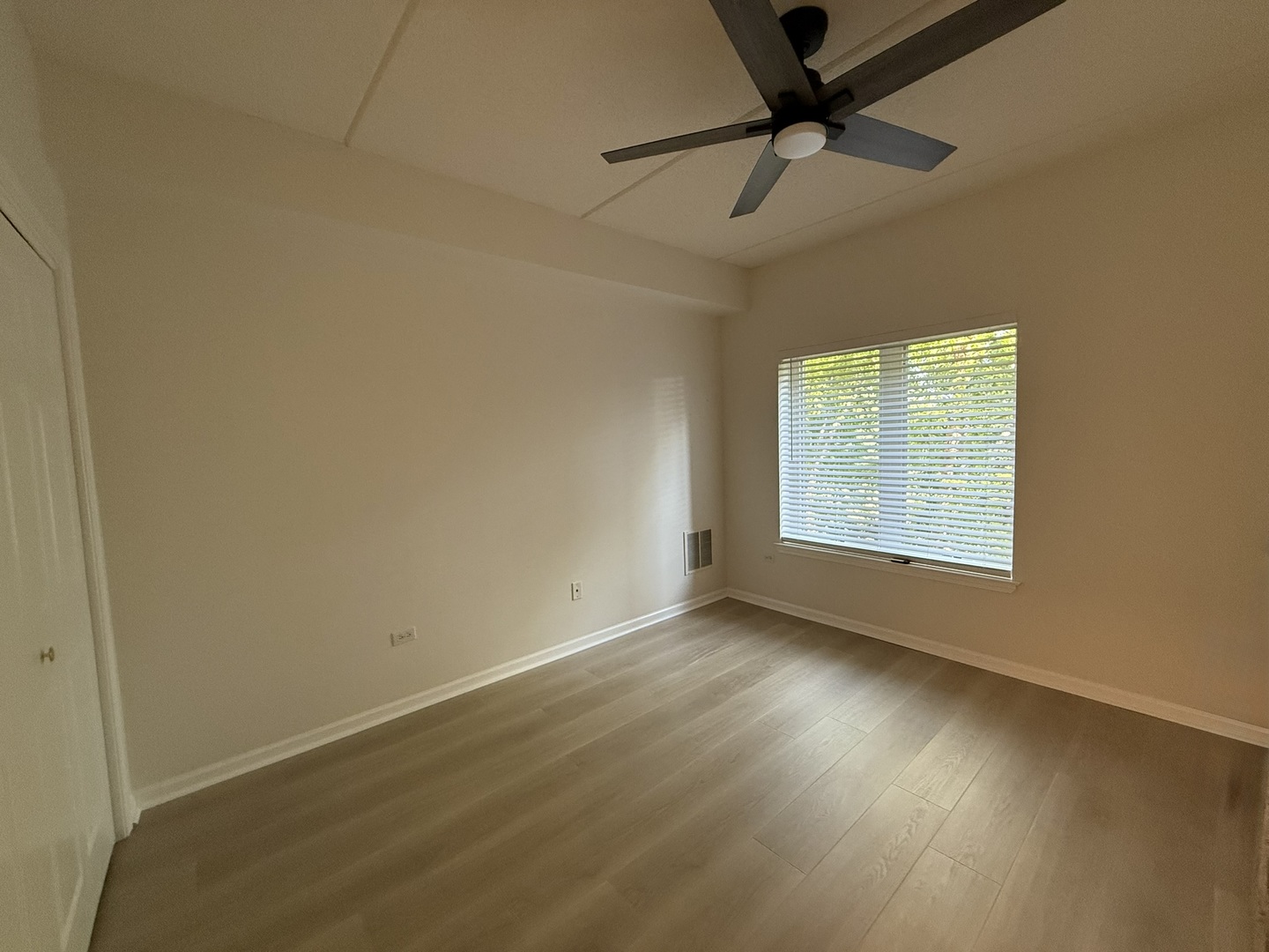 3401 North Carriageway Drive, Unit 307 Arlington Heights, IL 60004 - Photo 4 of 11 an empty room with a window and a ceiling fan