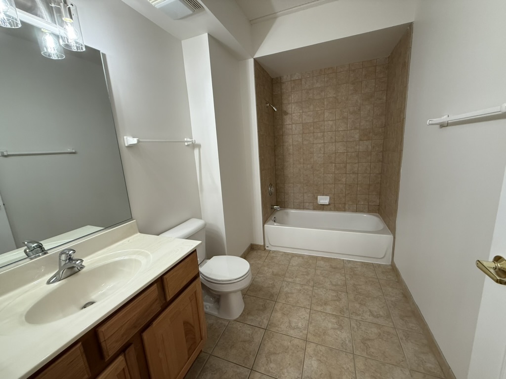 3401 North Carriageway Drive, Unit 307 Arlington Heights, IL 60004 - Photo 5 of 11 a bathroom with a sink a toilet and bathtub