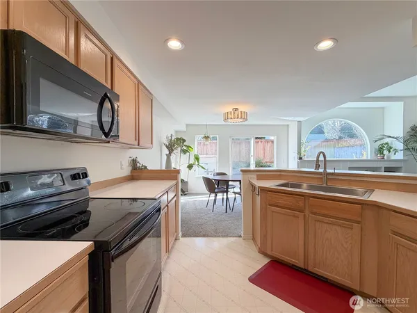 a kitchen with stainless steel appliances granite countertop a sink stove and microwave