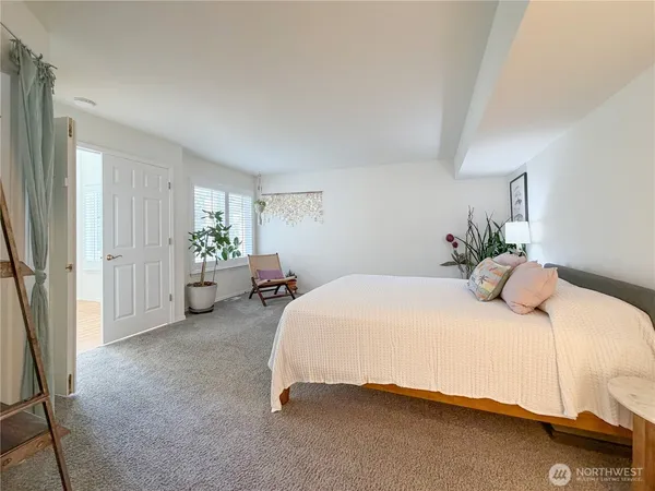 a bedroom with a bed and a potted plant