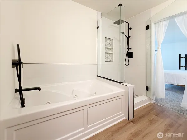 a bathroom with a tub sink and mirror