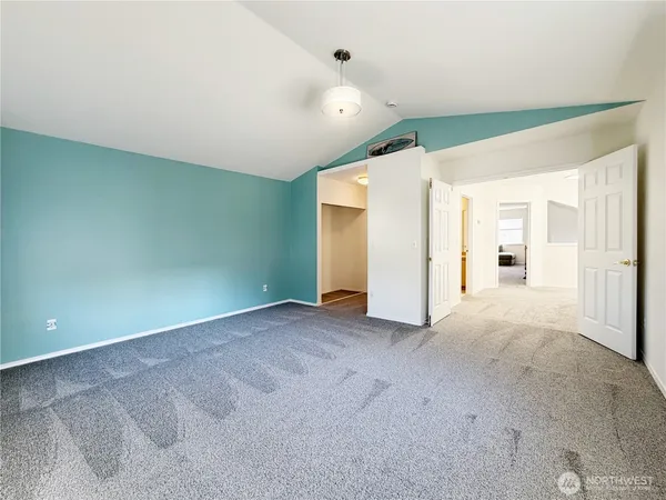 a spacious bedroom with a bed and a chandelier