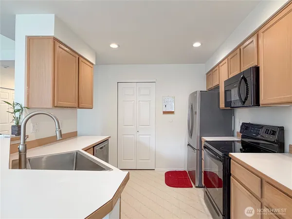 a kitchen with stainless steel appliances a refrigerator a sink a stove and cabinets