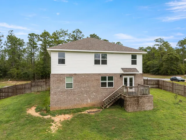a front view of house with yard and trees in the background