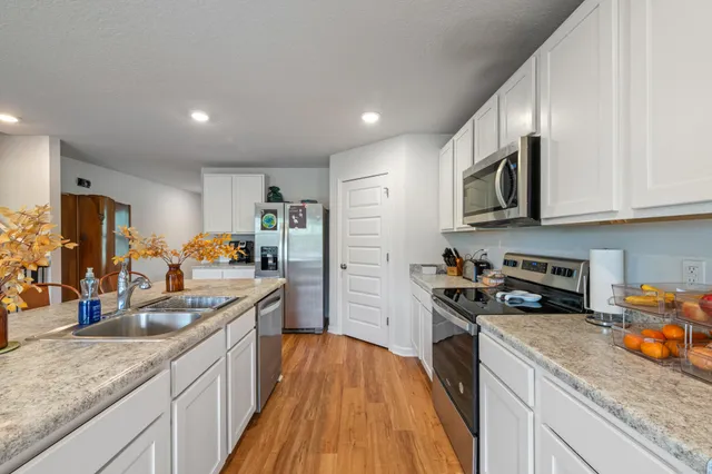 a kitchen with stainless steel appliances granite countertop a sink stove and refrigerator
