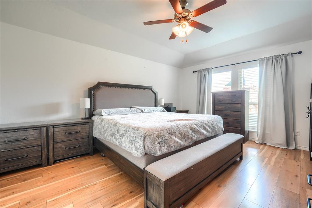 5604 Durst Lane Forney, TX 75126 - Photo 13 of 31 a bedroom with a large bed and a chandelier