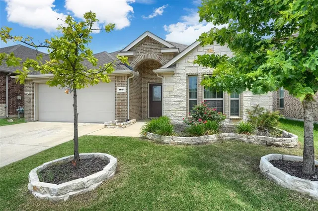 a front view of a house with a yard garage and fountain