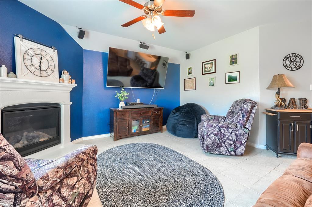 5604 Durst Lane Forney, TX 75126 - Photo 6 of 31 a living room with furniture a flat screen tv and a fireplace