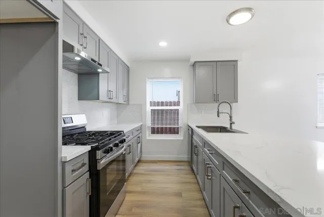 a kitchen with stainless steel appliances a sink stove and cabinets