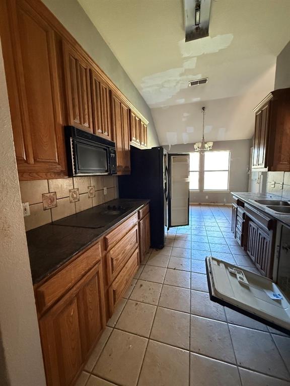 5424 Appalachian Way Fort Worth, TX 76123 - Photo 4 of 16 a kitchen with granite countertop a refrigerator a stove and a sink with wooden cabinets