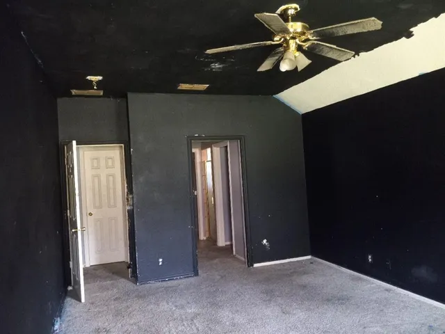 an empty room with closet and a chandelier fan