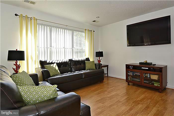 14201 Woolen Oak Court, Unit 432 Silver Spring, MD 20906 - Photo 3 of 20 a living room with furniture and a flat screen tv
