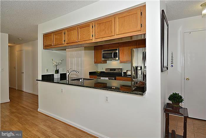 14201 Woolen Oak Court, Unit 432 Silver Spring, MD 20906 - Photo 7 of 20 a kitchen with stainless steel appliances a sink a stove and a refrigerator
