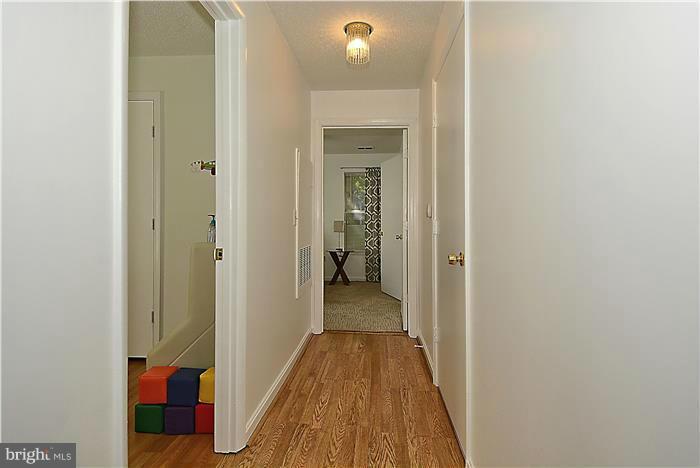 14201 Woolen Oak Court, Unit 432 Silver Spring, MD 20906 - Photo 8 of 20 a view of a hallway with wooden floor and a bathroom