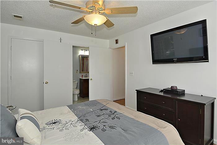 14201 Woolen Oak Court, Unit 432 Silver Spring, MD 20906 - Photo 10 of 20 a bedroom with a bed and a flat screen tv