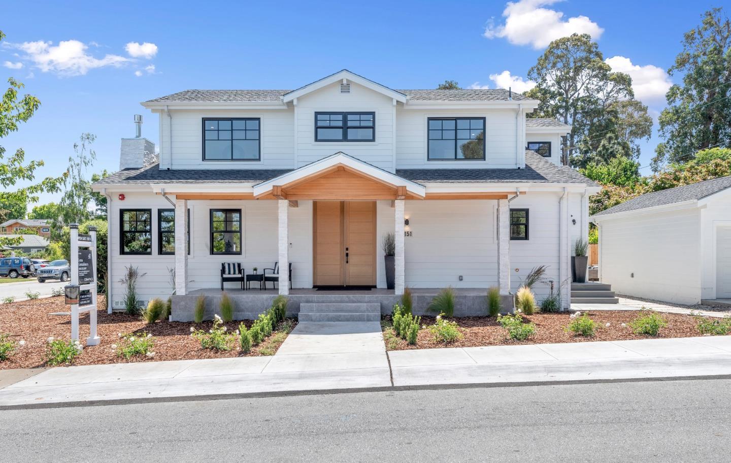a front view of a house with garage and plants