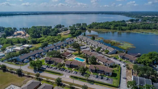 an aerial view of a residential houses with outdoor space and lake view