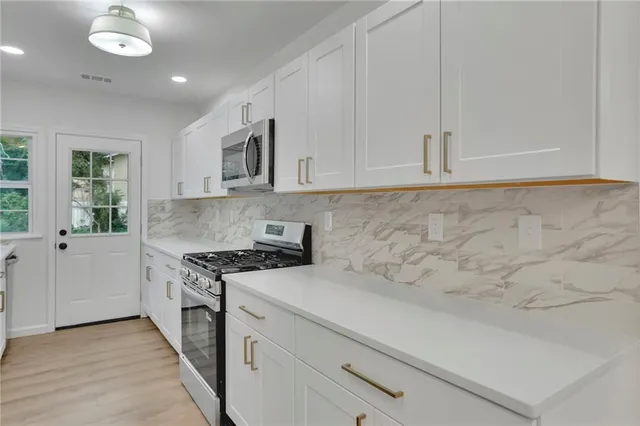 a kitchen with granite countertop white cabinets and white appliances