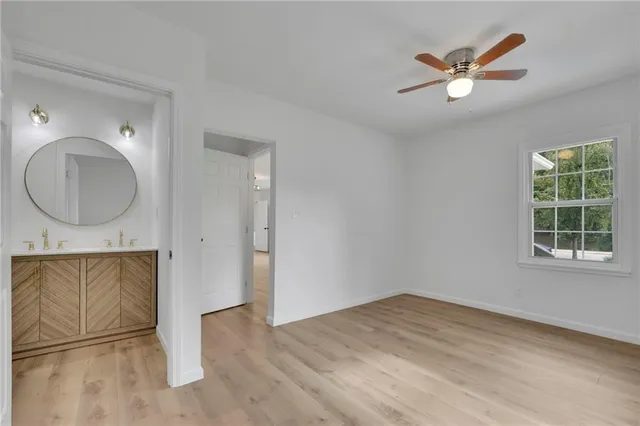 an empty room with windows and a ceiling fan