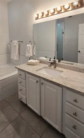 a bathroom with a granite countertop sink double and mirror