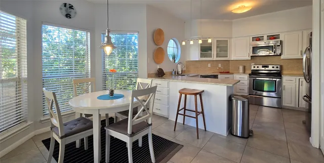 a kitchen with a table chairs stove and refrigerator