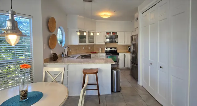 a kitchen with stainless steel appliances granite countertop a sink and a refrigerator