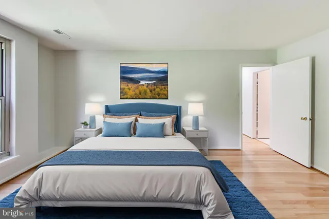 a bedroom with a bed and wooden floor