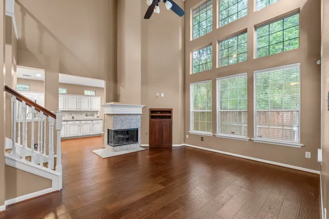 a view of a livingroom with fireplace wooden floor and windows