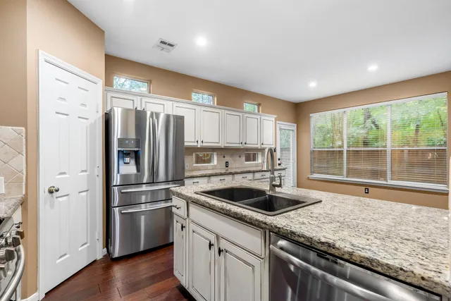 a kitchen with a refrigerator a sink and cabinets