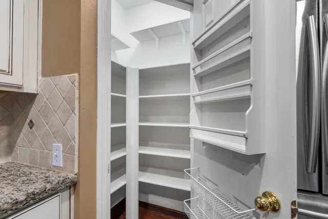 a view of walk in closet with wooden floor
