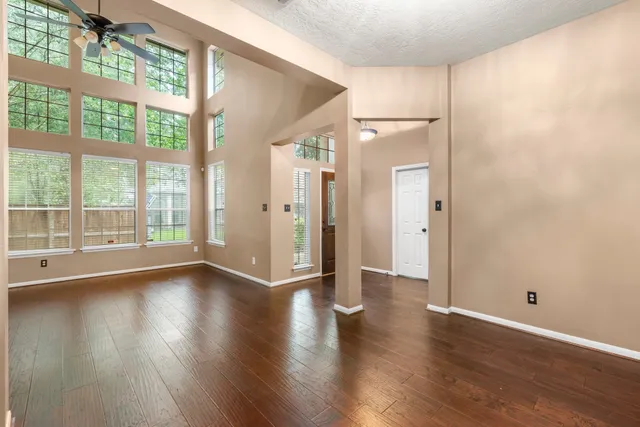 a view of a big room with wooden floor and windows