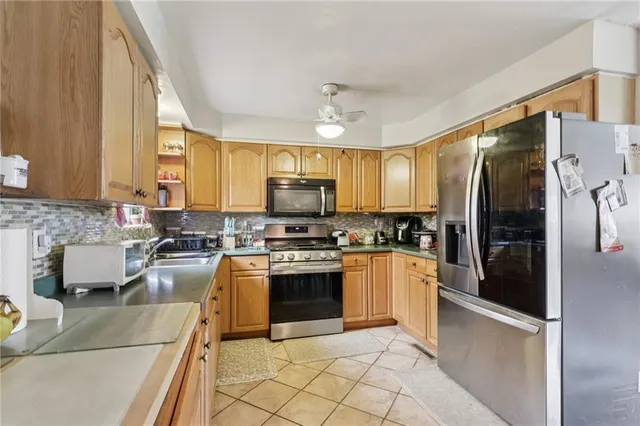 a kitchen with stainless steel appliances granite countertop a refrigerator a stove top oven a sink and dishwasher