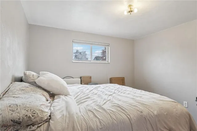 a bedroom with a bed and a painting on the wall