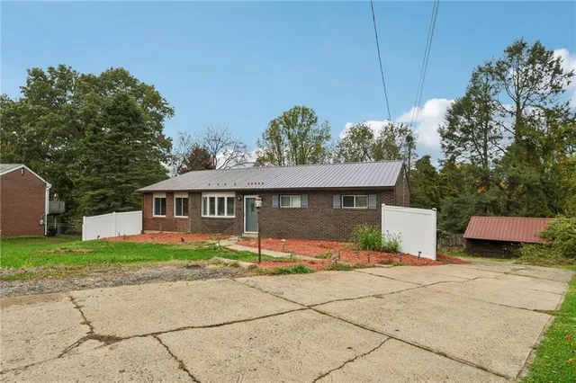 a front view of a house with a yard and potted plants
