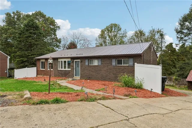 a front view of a house with a garden and plants