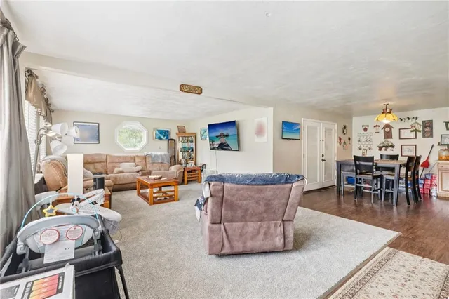 a living room with furniture and a dining table with chairs