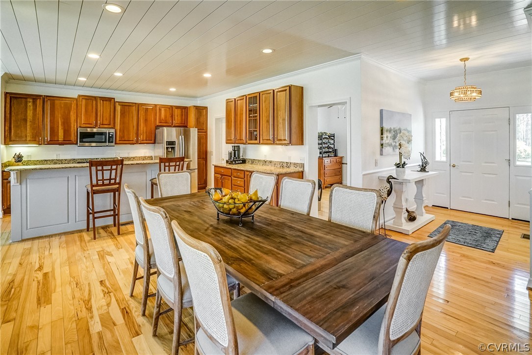 253 Prentice Point Drive Kilmarnock, VA 22482 - Photo 15 of 44 a living room with dining table a stove and a dining table with wooden floor