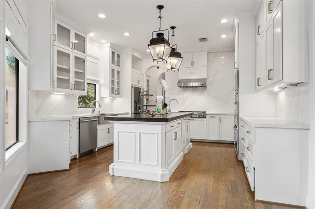 a kitchen with white cabinets and sink