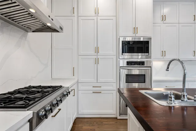 a kitchen with kitchen island white cabinets and stainless steel appliances