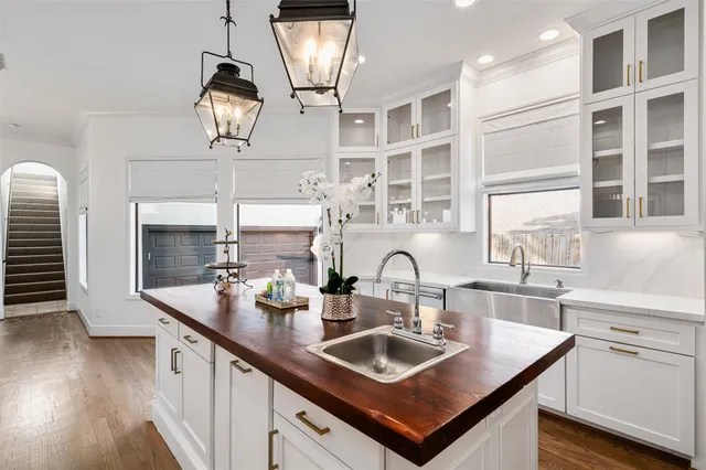 a kitchen with a sink a counter space appliances and cabinets