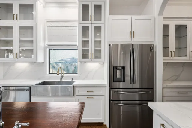 a kitchen with stainless steel appliances granite countertop a refrigerator and a sink