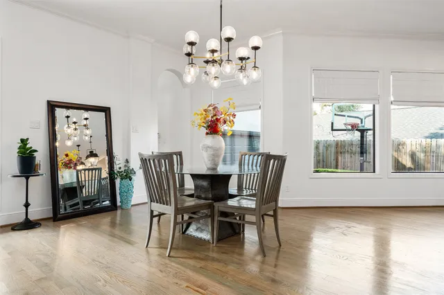 a view of a dining room with furniture a chandelier and wooden floor